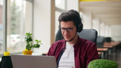Developer, video editor man in headphones working with laptop at spacious Stock Footage 220072910
