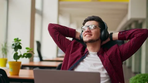 Developer, video editor man in headphones working with laptop at spacious Stock Footage 220726458