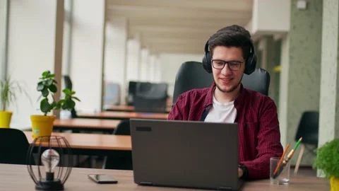 Developer, video editor man in headphones working with laptop at spacious Stock Footage 221092192