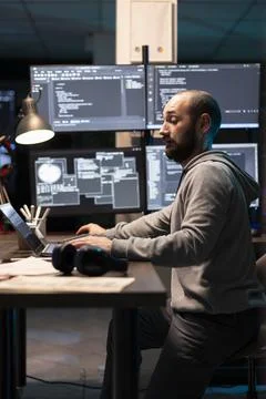 Developer Working Across Multiple Screens in Tech Office Foto stock