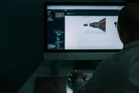 Developer, working behind the desk, analysing diagram on the monitor Stockfoto's