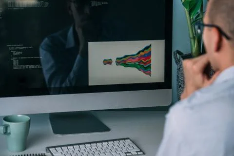 Developer, working behind the desk, analysing diagram on the monitor Stockfoto's