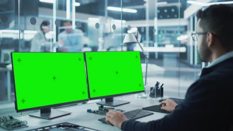 Developer Working on Computer with Two Green Screens Stock Footage 224520863