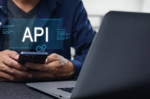 Developer Working on Mobile API Interface with Laptop and Phone Stock Photos