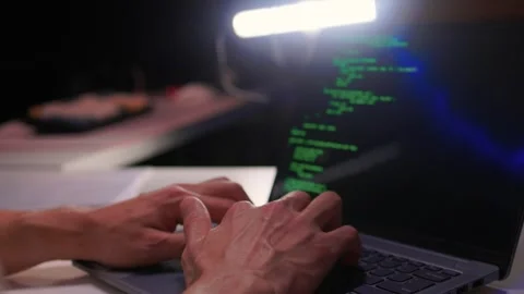 Developer working under dim light. Night coding session with glowing screen and Stock Footage 346244797
