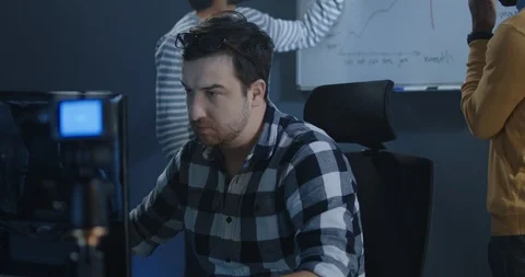 Developer working while colleagues discussing 스톡 동영상 125171029