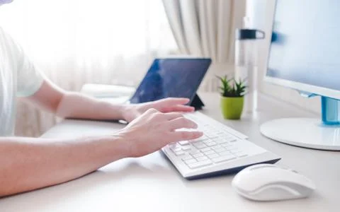The developer works at the computer, typing, uses the mouse. Selective focus Photos