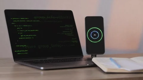 Developer workspace with programming code on laptop and AI phone assistant Stock Footage 346834769