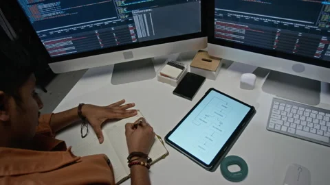 Developer Writing Notes at Workstation with Screens of Code 스톡 동영상 348377919