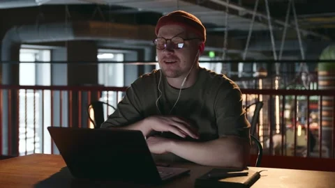 The developer is a young man communicating via video link with his colleagues Stock Footage 258966970