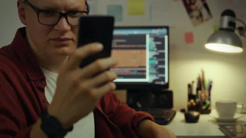 Developer. Young man using intelligence to optimize code for smartphones in Vídeos de archivo 281418865