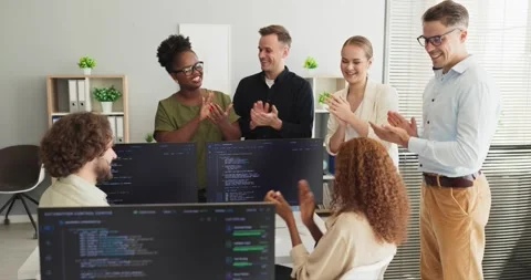 Developers applaud a programmer success at office with multiple coding screens Video stock 336490551