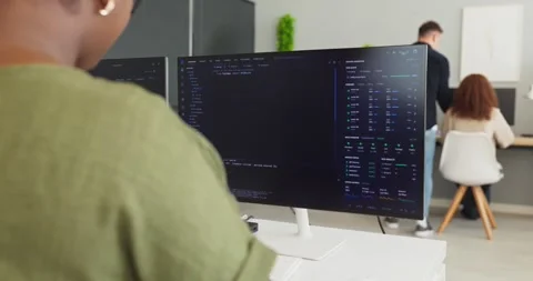 Developers collaborating on code at computers in office workspace, software team 스톡 동영상 341661170
