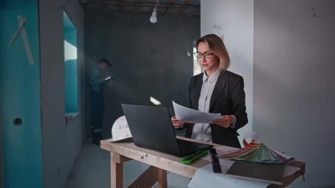 The developer's company specialists work at the construction site. A woman Stock Footage 297049626