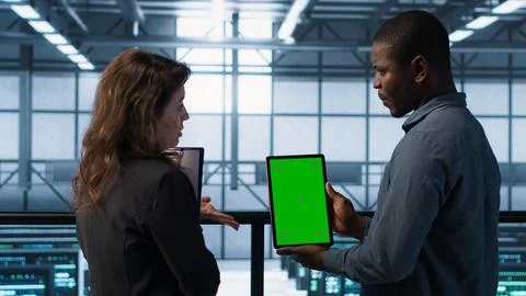 Developers in data center using mockup tablet, observing performance analytics Foto stock