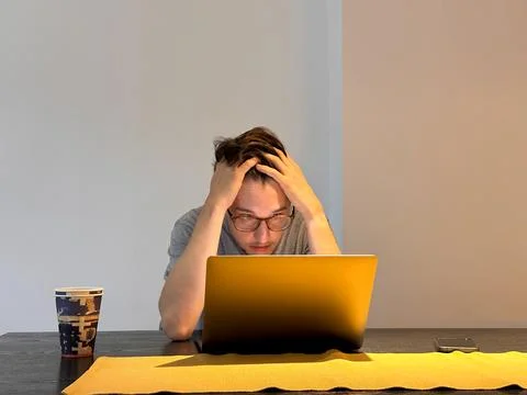 The developers face expresses desperation, hands wrapped around his head Stock Photos