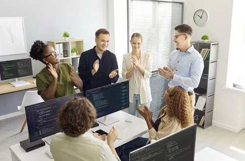 Developers team applauding coding success in modern startup office meeting Stock Photos