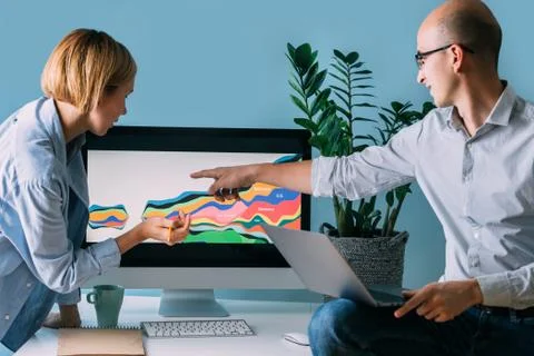 Developers, working on displayed diagram, analysing it together Stock Photos