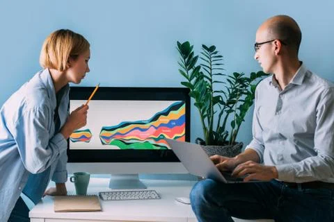 Developers, working on displayed diagram, analysing it together Stock Photos