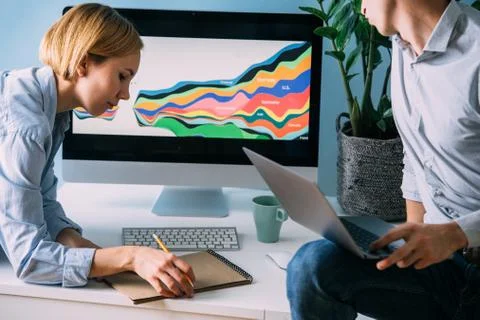 Developers, working on displayed diagram, analysing it together Stock Photos