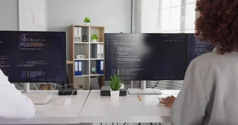 Developers working at multiple monitors with code, teamwork collaboration in Stock Footage 340407709