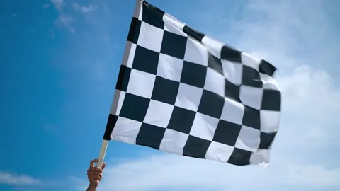 A developing checkered racing flag made of wavy silk fabric in the hand of a man Video stock 268949325