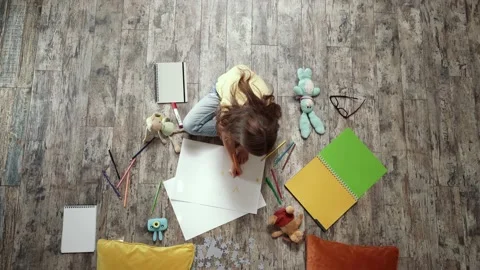 Developing creativity. Top view of little girl sitting on the wooden floor and Video stock 140498580
