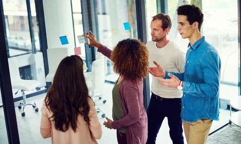 Developing ideas that stand out. a group of young designers brainstorming with Foto stock