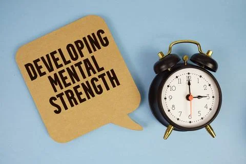Developing Mental Strength text with alarm clock on blue background Stock Photos