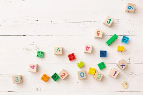 Developing multi-colored cubes on a white wooden table. Wooden cubes Stock Photos