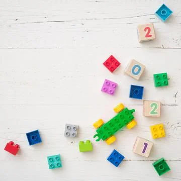 Developing multi-colored cubes on a white wooden table. Wooden cubes Stock Photos