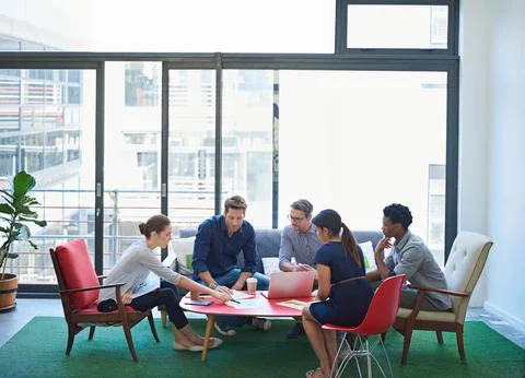Developing new strategies. a group of office workers talking together in a Stock Photos