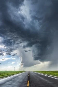 A developing severe thunderstorm with large hail crosses the highway in Colorado Foto stock