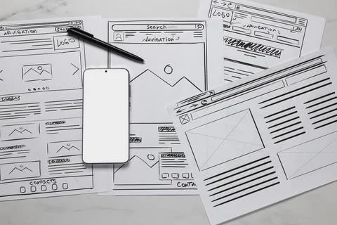 Developing UI design. Sketches of website wireframes, smartphone and pen on.. Stock Photos