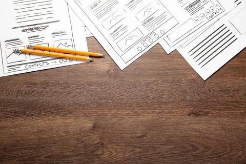 Developing UI design. Sketches of website wireframes and pencils on wooden .. Stock Photos