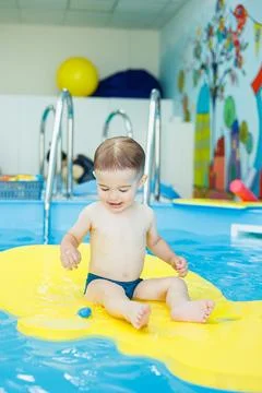 Development for babies. A little boy is learning to swim in the pool. Childre 写真素材