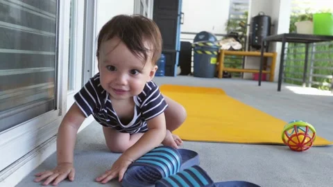 The development of a baby 8-10 months old who is learning to walk and learns Stock Footage 180286437