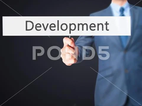 Development - Business man showing sign Stock Photos
