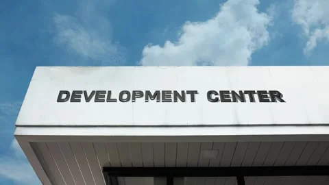 Development center word sign displayed on building with blue sky background Stock Footage 318623157