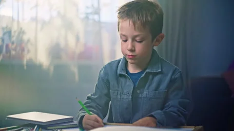 Development of a child's imagination, a boy draws with pencils on paper. Stock Footage 283470663