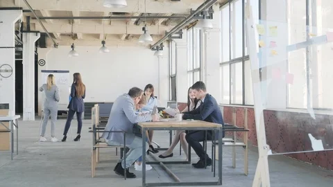The development team holds a meeting at the desk in the loft-style office space Stock Footage 109504146