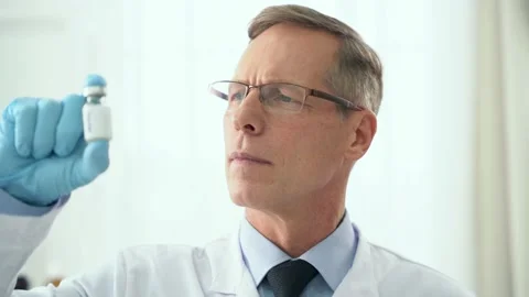 Development of the vaccine. Close up of middle aged male doctor holding and Stock Footage 144496503