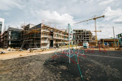 Developmental playground with construction cranes and site in the background Stock Photos