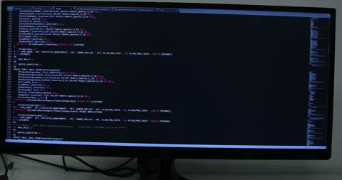 Develper writing sql code in monitor working from home Stock Footage 243624031