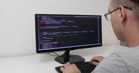 Develper writing sql code in monitor working from home Video stock 243630502