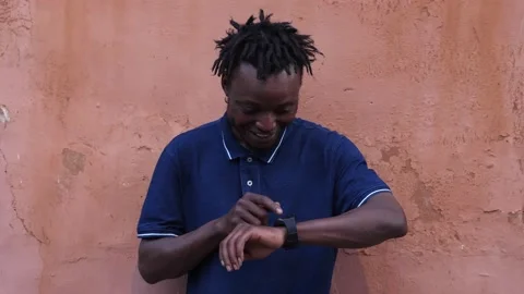 Device, accessories- smiling black man types on his smartwatch Stock Footage 220718474