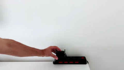 Device connects to sleek power strip on white desk-minimalist setup Video stock 314706952