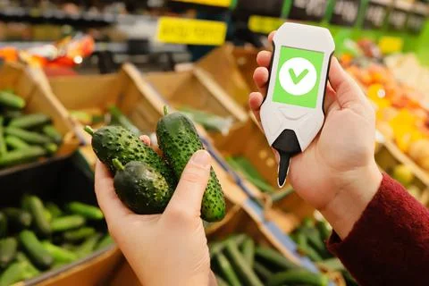 Device in hand measuring nitrates and pesticides on market vegetables and fruits Stock Photos