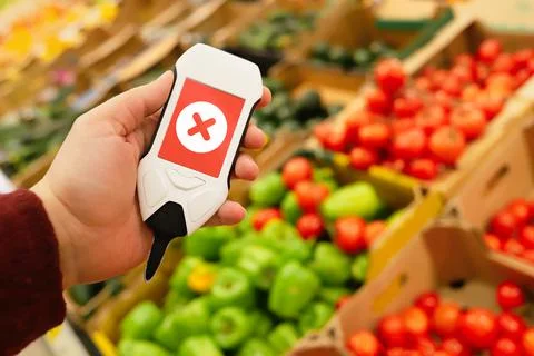 Device in hand measuring nitrates and pesticides on market vegetables and fruits Stock Photos
