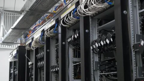 Device for mining crypto currency. Row of bitcoin miners set up on the wired Stock Photos